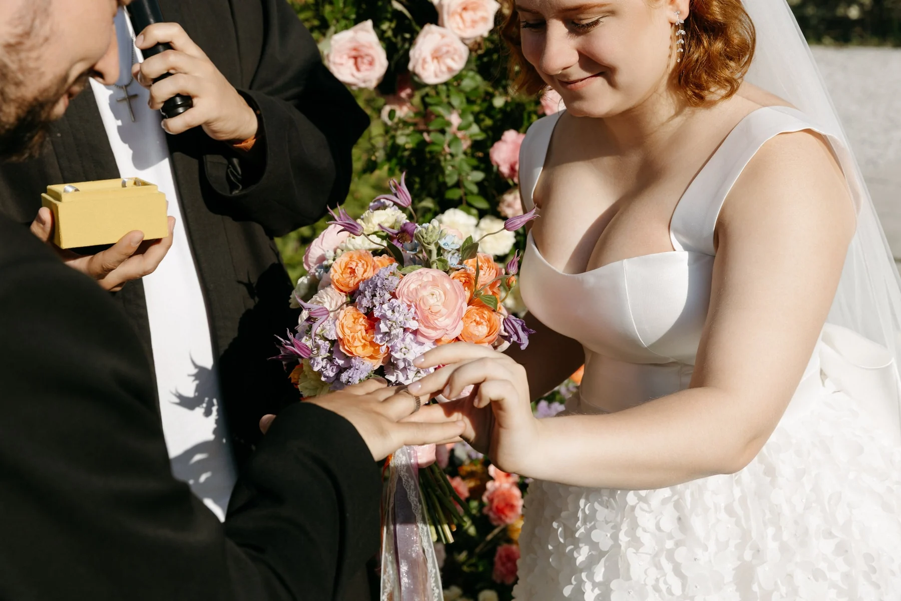 Digital photograph of a bride receiving her wedding ring during an outdoor ceremony