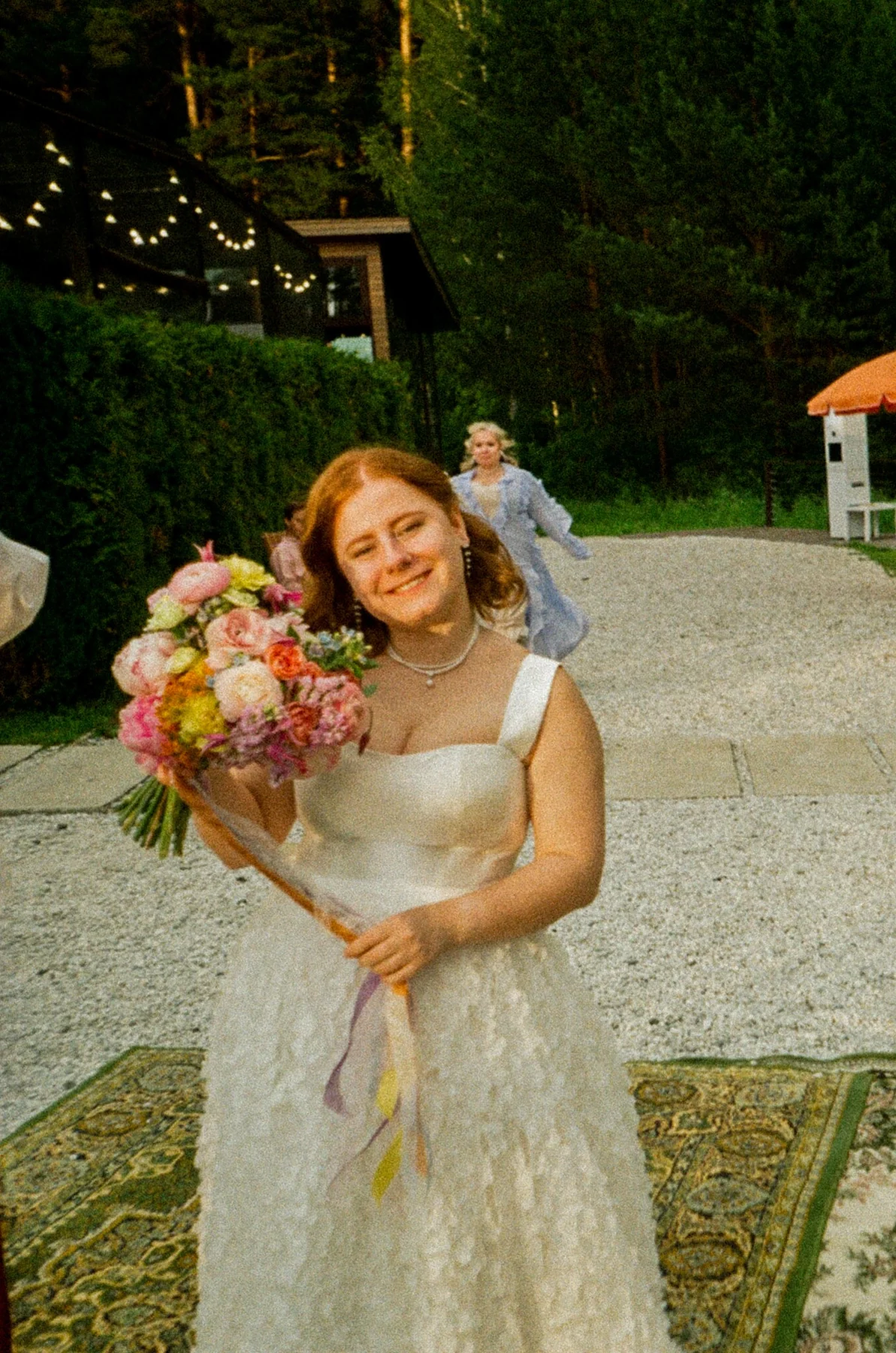 Bride holding a colourful bouquet in a sunlit portrait photographed on film