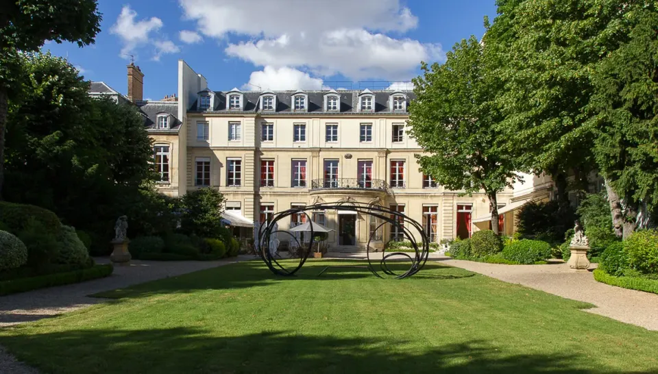 Formal garden and façade of Maison de l’Amérique latine in Paris
