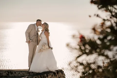 Newlyweds beside the caldera at Santorini Gem